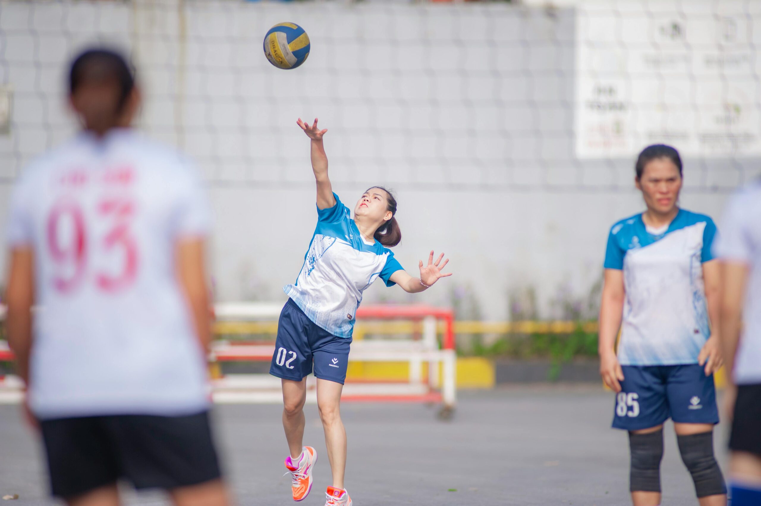 Frauen spielen ein Volleyballspiel im Freien in Hanoi, Vietnam.